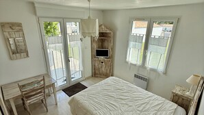 A bedroom with a bed, a desk, a chair, a TV, and a window. - House Sainte-Marie de Ré (Sainte-Marie-de-Ré)