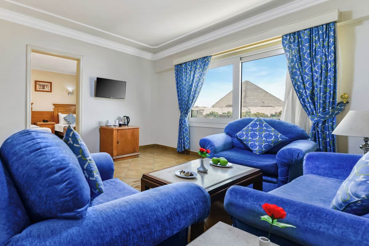 A living room with blue sofas, a coffee table, and a TV.