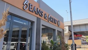 Une devanture de magasin avec une enseigne indiquant « Beans & Brew ».