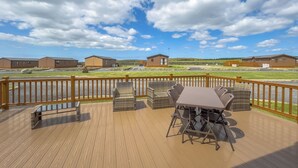 Une terrasse dotée de mobilier d’extérieur, offrant une vue sur les b âtiments et un ciel dégagé.