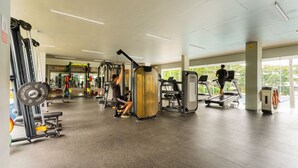 Un gimnasio con diversos equipos de ejercicio, incluyendo cintas de correr y máquinas de pesas.