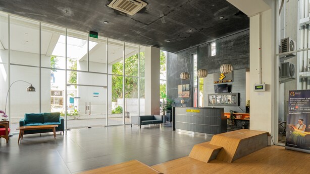 Un área de recepción moderna con mostrador, asientos y vistas al exterior.