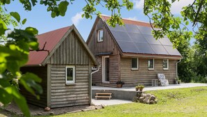 Ein Holzhaus mit geneigtem Dach und Solaranlage.