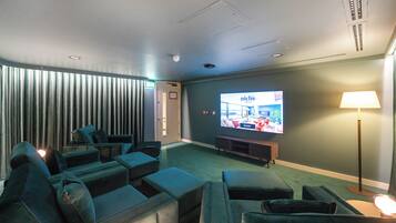 A modern lounge with a flat-screen TV displaying 'Niche Living', a sofa area, and a lamp.