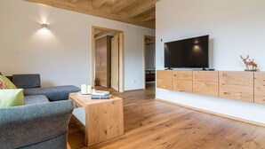 A modern living room with a flat-screen TV, wooden cabinets, a sofa, and a coffee table. - Apartment 'Dollenberg' with Mountain View, Balcony and Wi-Fi (Bad Peterstal-Griesbach)