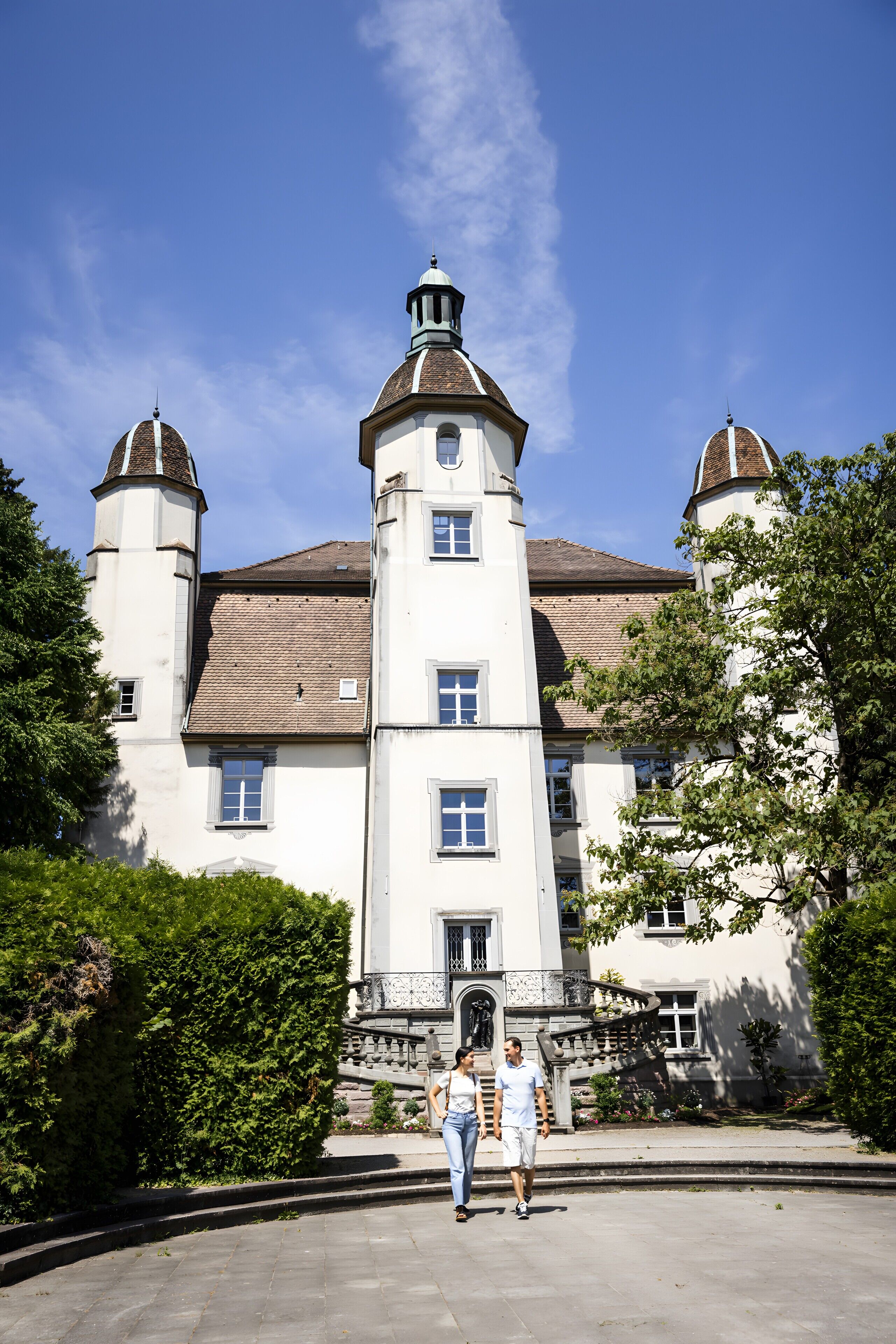 A large, historic building with a central tower, multiple windows, and a symmetrical facade.