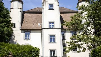 A large, historic building with a central tower, multiple windows, and a symmetrical facade.