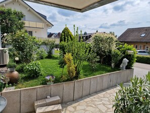 Un jardin résidentiel agrémenté de diverses plantes et doté d’un mur en pierre.