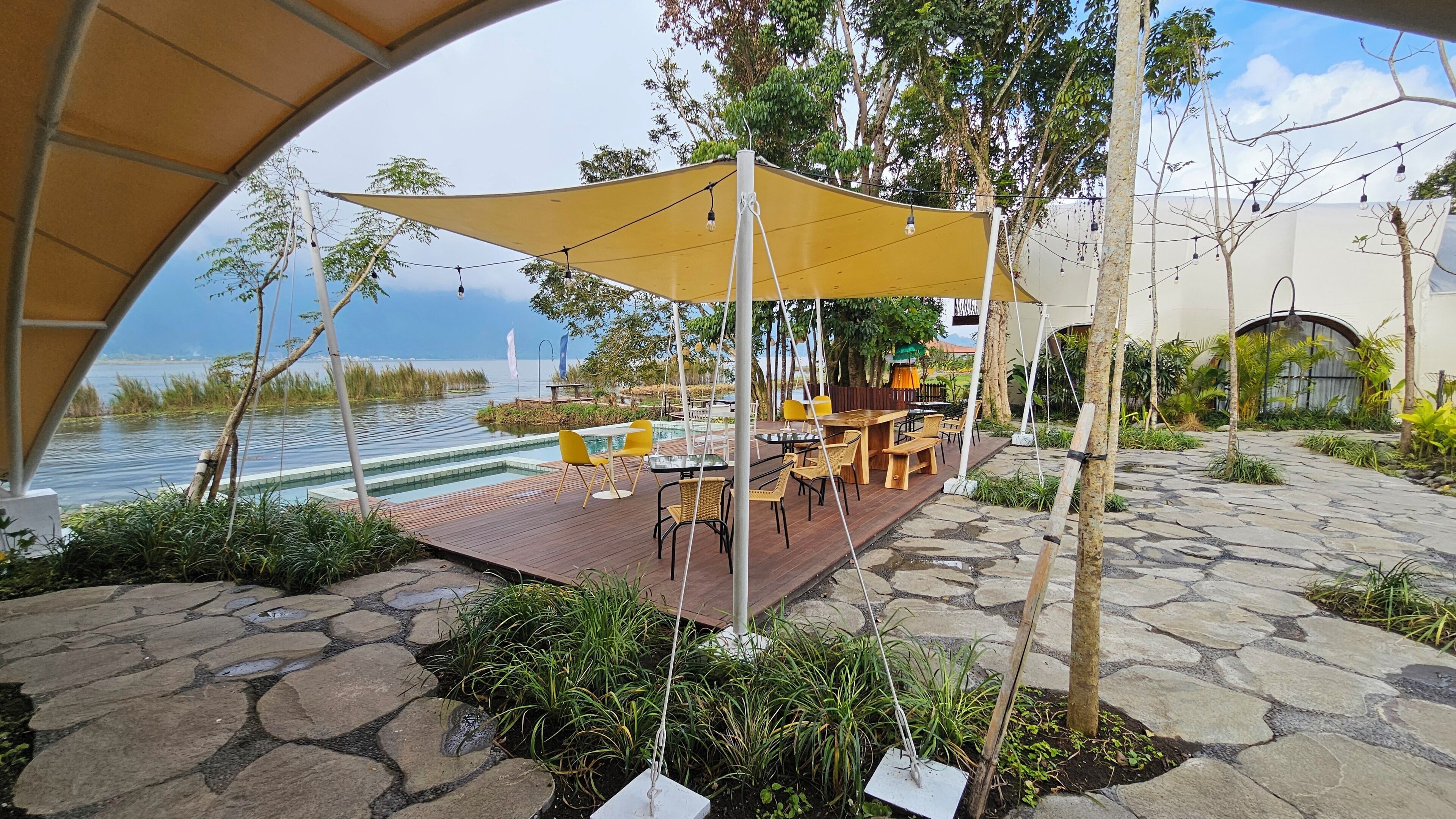 An outdoor patio with a pool, dining area, and a view of the water.
