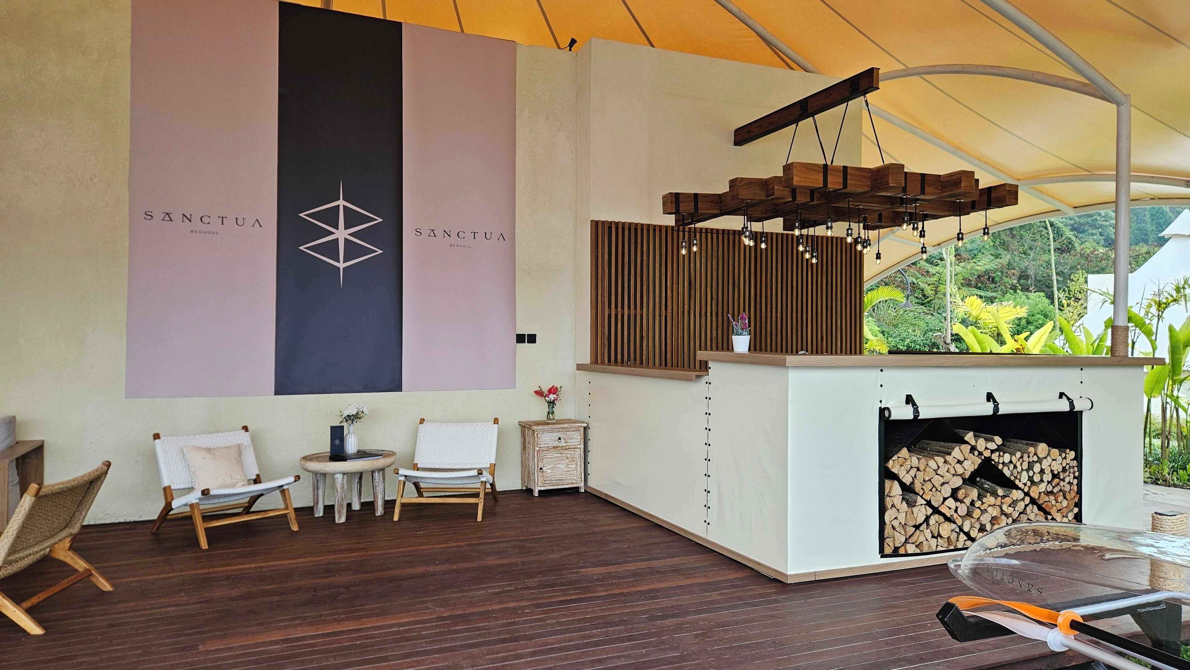 A modern interior with a fireplace, wooden furniture, and a large wall with branding.