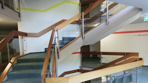 A multi-level interior with a staircase featuring wooden handrails and glass railings. - Apartment 'Lived-in' with Mountain View, Balcony and Wi-Fi (Bad Urach)