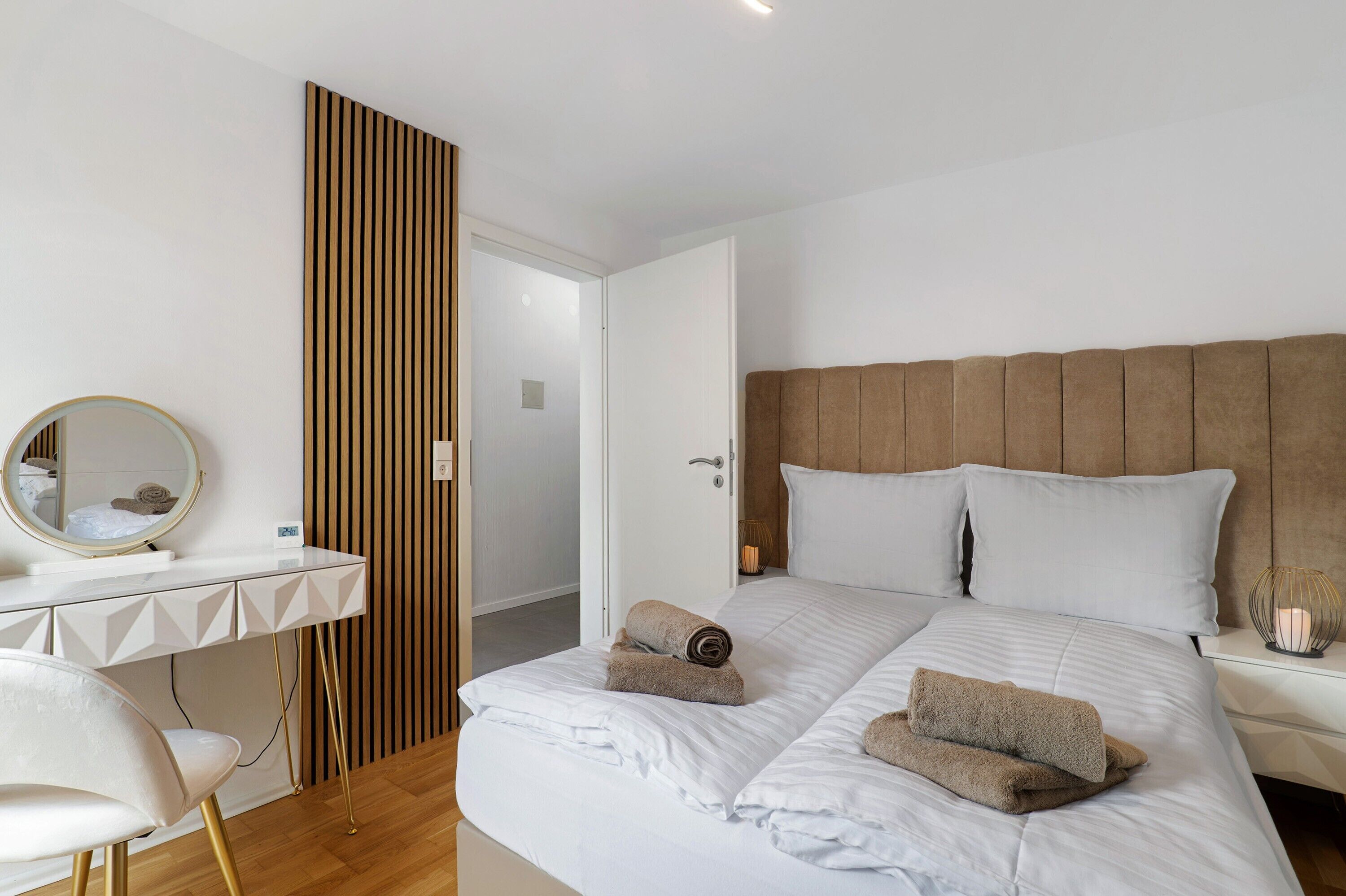 Une chambre d’hôtel moderne équipée d’un lit, d’un bureau, d’une chaise et d’un miroir.