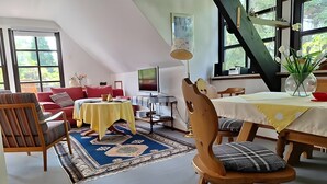Un salón amplio con una mesa de comedor, un sofá y una silla de madera.