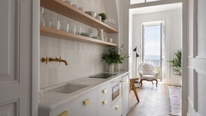 Eine moderne Küche mit weißen Schränken, einem eingebauten Ofen und Blick auf einen Balkon.