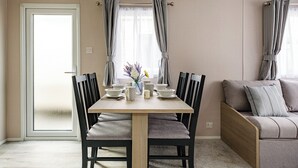 A dining area with a table, chairs, and a sofa.