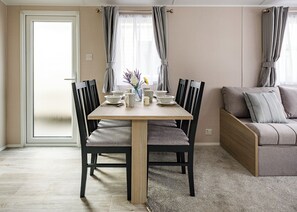 Ruokailutila, jossa on pöytä, tuoleja ja sohva.