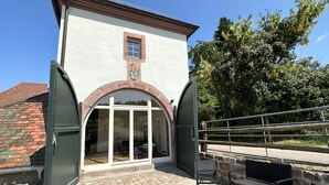 Un bâtiment à la façade blanche, orné de blasons et doté d’une grande entrée en arc de cercle.