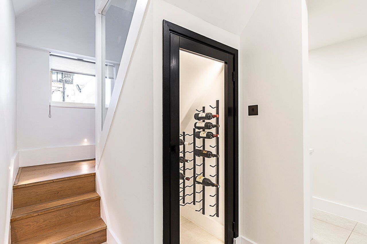 A staircase leading to a room with a wine rack holding several bottles.