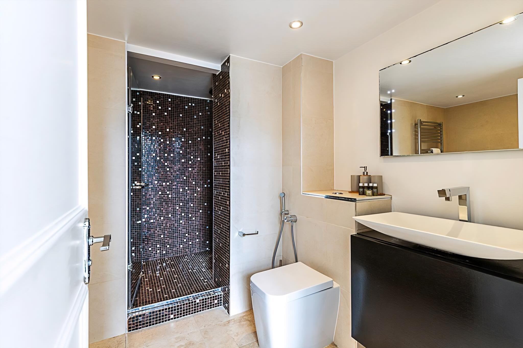 Een moderne badkamer met een douche, een wastafel en een toilet.