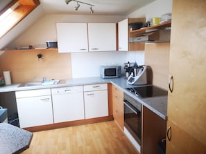 Cocina compacta con microondas, cafetera y lavavajillas.