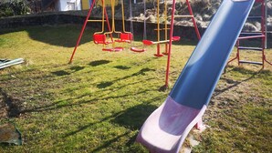 A playground with a slide, swings, and a climbing structure. - Apartment 'Eckert' with Shared Garden, Balcony and Wi-Fi (Wehr)