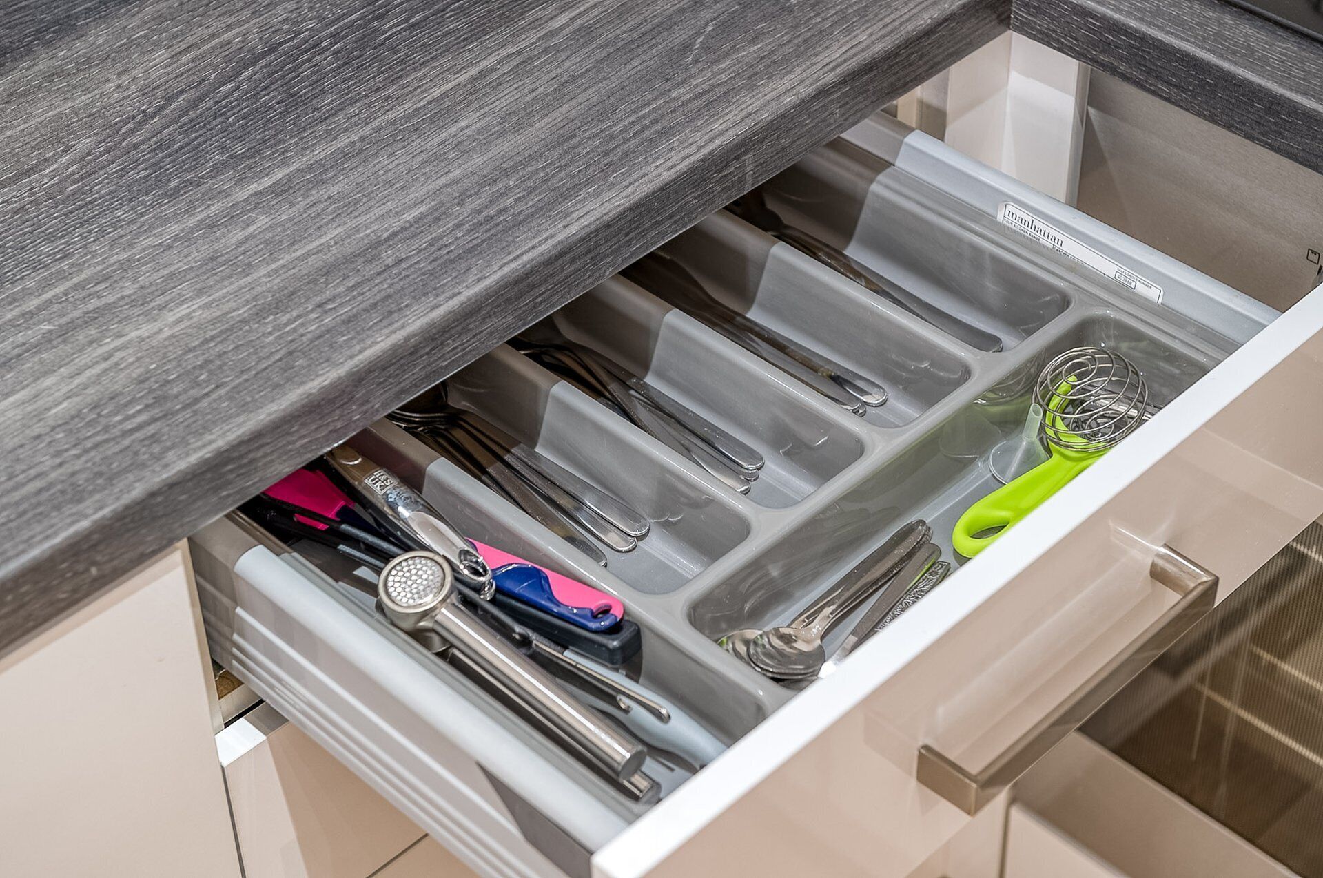 A drawer with utensils and kitchen tools.