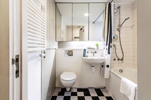 A compact bathroom with a toilet, sink, and bathtub.