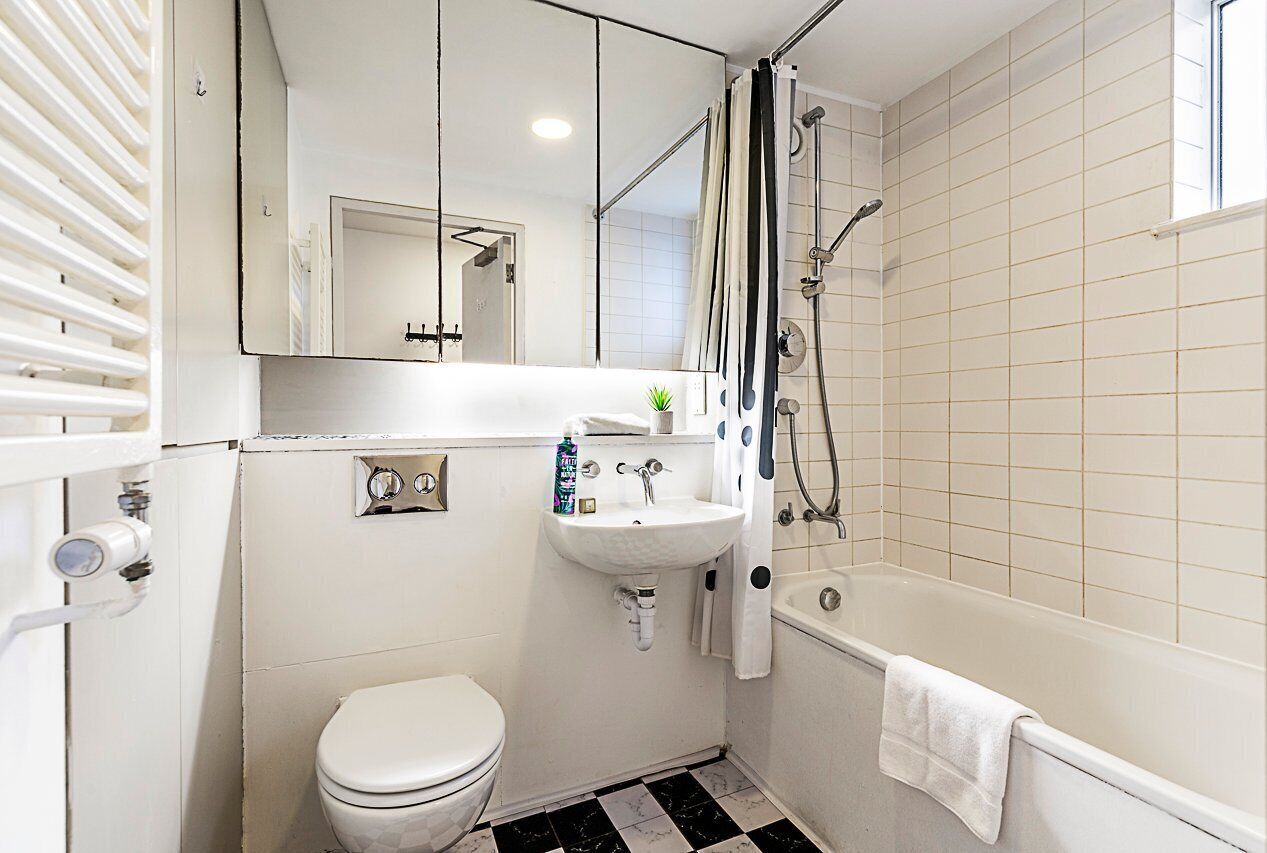 Ein kleines Badezimmer mit Toilette, Waschbecken und Badewanne.