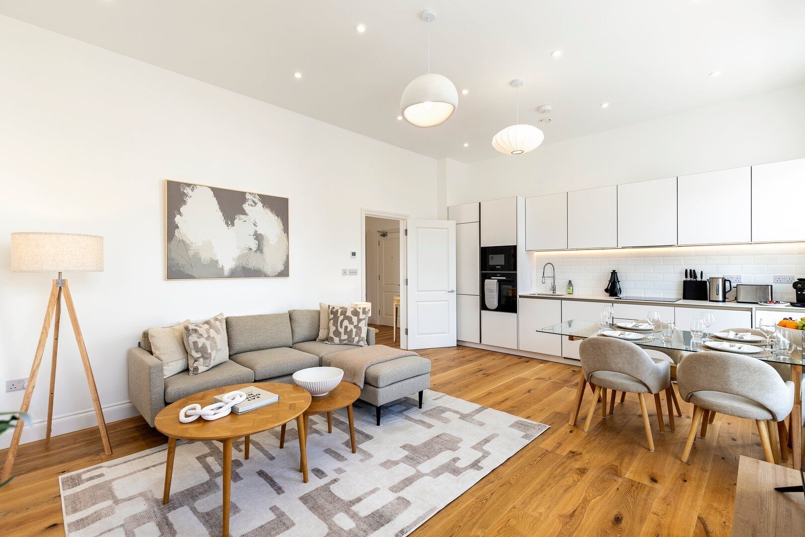 A modern apartment with a living room, dining area, and kitchen.