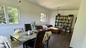 Ein Essbereich mit Tisch, Stühlen und einem Bücherregal im Hintergrund.