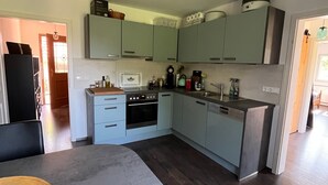 Eine moderne Küche mit hellblauen Schränken, einem eingebauten Backofen und einer zentralen Kochinsel.