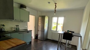Eine moderne Küche mit einer zentralen Kochinsel, einem eingebauten Backofen und einem Fenster für natürliches Licht.