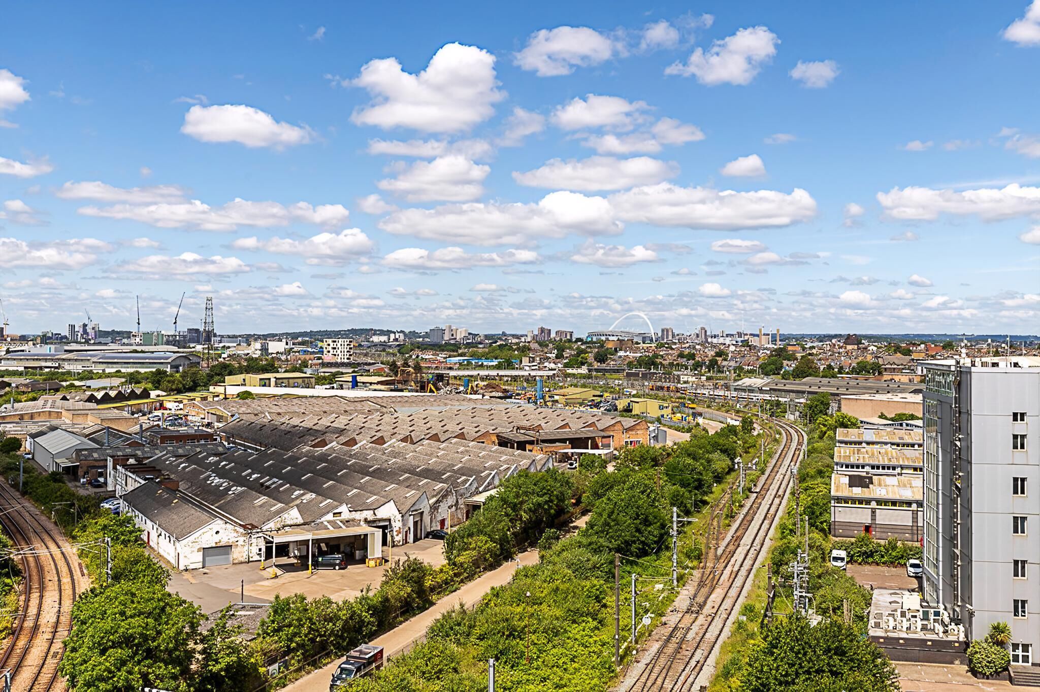 A large industrial area with multiple warehouses, railway tracks, and a modern building.