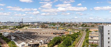 A large industrial area with multiple warehouses, railway tracks, and a modern building.