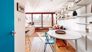 A modern kitchen with white cabinetry, a round dining table, and blue chairs.