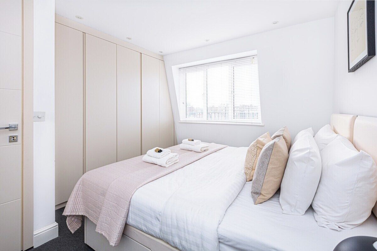 Une chambre à coucher avec un lit, une fenêtre et une armoire.