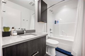 Un baño moderno con tocador de doble lavabo, inodoro y ducha a ras de suelo.