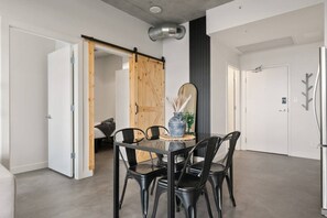 Een modern interieur met een eettafel, stoelen, een spiegel en een schuifdeur.