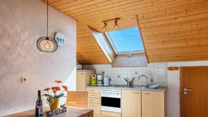Una cocina con armarios de madera, una estufa, un fregadero y un tragaluz.