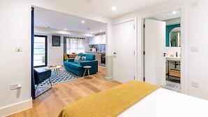 A modern apartment with a living area, kitchenette, and a bedroom with a bed. - Cosy and Stylish Studio in the Heart of Greenwich (London)
