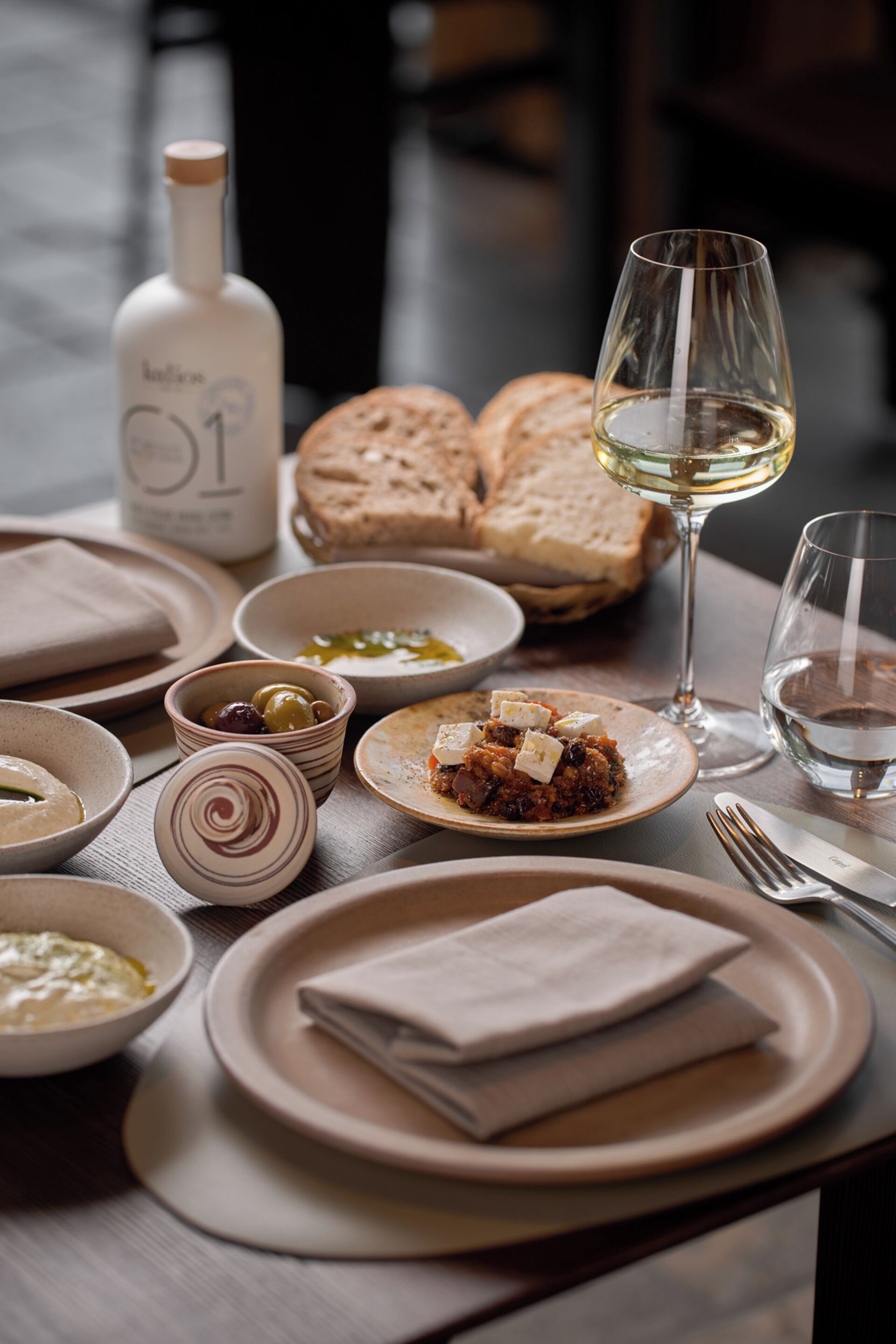 A table set with various dishes, a bottle, and glasses, suggesting a dining setting.