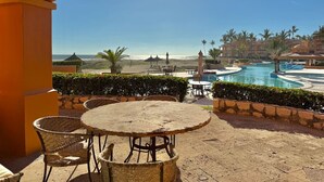 An outdoor seating area with a view of a pool and beach. - Depa in EDM first floor beachfront By GPS (Mazatlán)
