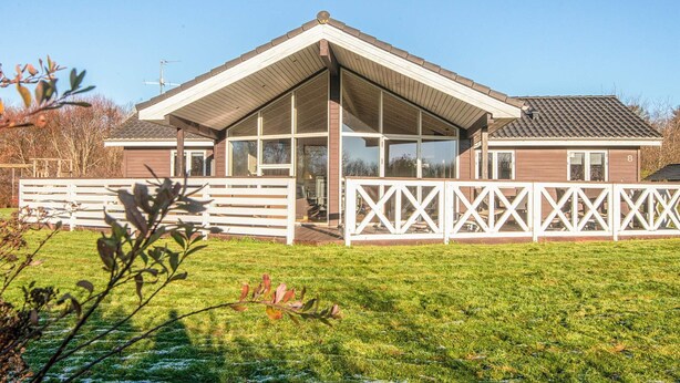 A two-story house with a large front porch and a fenced backyard. - 4 Star Holiday Home in Hemmet (Hemmet)