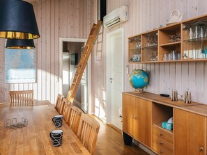 A wooden dining area with a table, chairs, and a globe on a cabinet. - 4 Star Holiday Home in Hemmet (Hemmet)