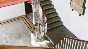 A staircase with a wooden handrail, white balusters, and a patterned floor. - For Students Only Queen's Hospital Close near Birmingham City Centre (Birmingham)