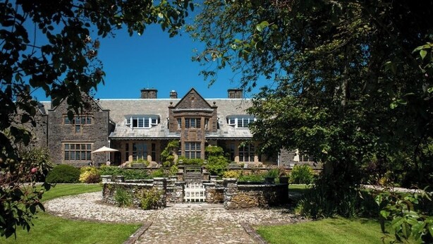 A large stone building with a central entrance, surrounded by a well-maintained garden and a gravel pathway leading to the entrance. - Luxurious 4 bedroom apartment @Pickwell Manor on North Devon Coast near Croyde (Georgeham)