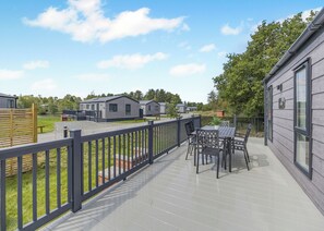 A deck with outdoor furniture, a view of mobile homes, and a clear sky. - 2 bedroom accommodation in Woodhall Spa (Woodhall Spa)