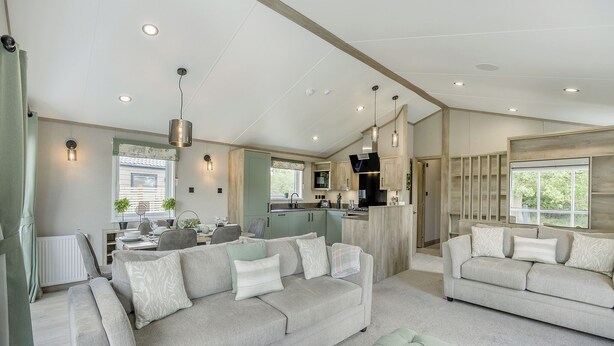 A modern living room with a sofa, ottoman, and dining area.