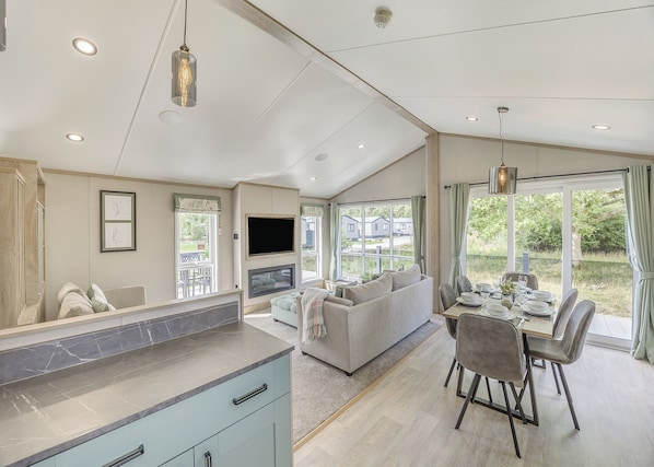 A spacious living area with a sofa, dining table, and TV.
