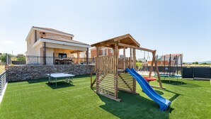 A backyard with a wooden play structure, a slide, and a table tennis table. - Villa Alba Zadarvillas (Pakostane)